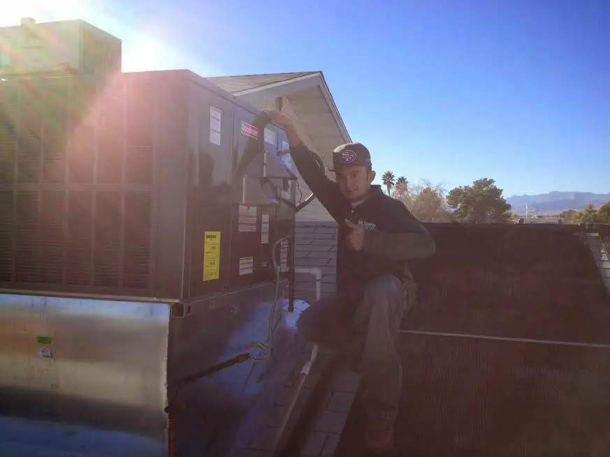 HVAC technician performing Heat Pump Repair on a rooftop unit in Duncan